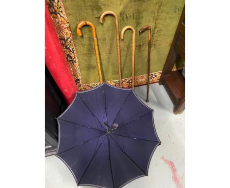 Four various walking sticks together with an amber handle Paragon S. Fox &amp; Co parasol. One walking stick contains a hidde