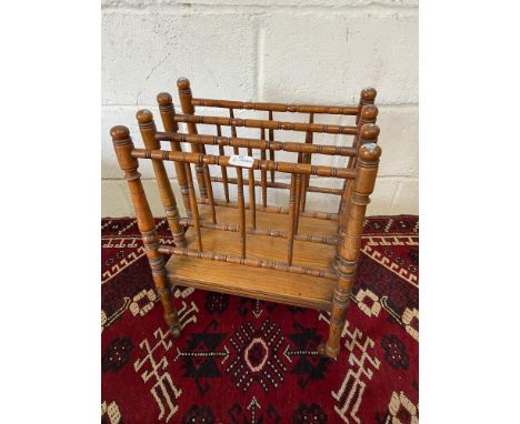 An Antique oak Canterbury. Finished with original brass and ceramic castors. [H:52CM X L:41CM W:26CM] 