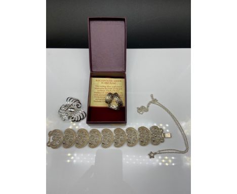 An ornate silver bracelet, Mackintosh silver scarf ring, Silver swirl brooch and a silver star pendant and chain. 