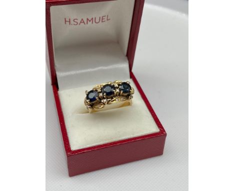 A Lovely example of a ladies 14ct gold [585] ring set with three large Sapphires [each measure 5mm]surrounded by diamonds. [7