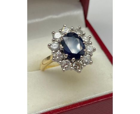 An Exquisite ladies 18ct gold ring set with a large sapphire surround by 1.94ct of diamonds. [Sapphire measures approx. 9.5x7