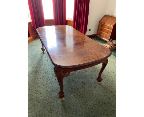 An Impressive Antique Burr Walnut wideout dining table. Designed with heavy carved leg supports detailing carved ball and cla