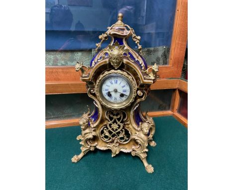 An Antique Porcelain mantle clock designed with Ormalu mounts. White enamel face with blue roman numerals. Gustav Becker move
