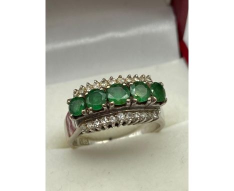 A Ladies 14ct 585 white gold Emerald and diamond ring. Designed with five 3.75mm emeralds and diamonds to either side. [0.85c