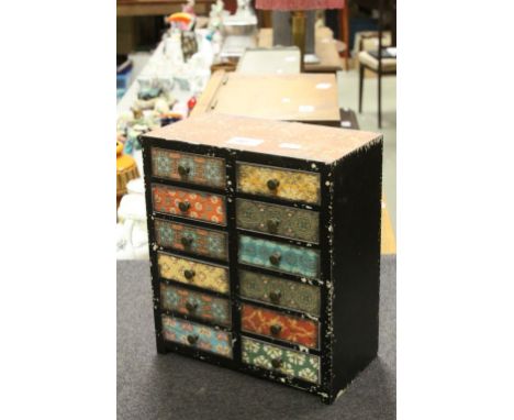 A vintage hand painted decorated miniature chest of 12 drawers.