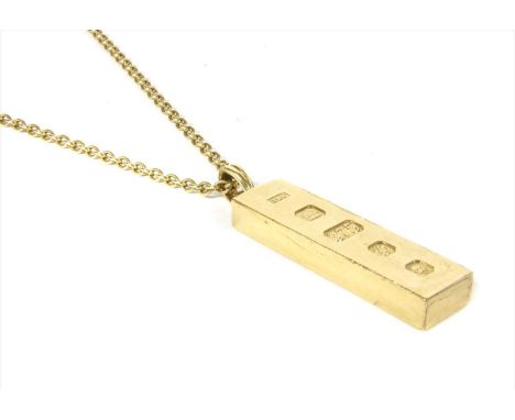 A 9ct gold rectangular ingot pendant, with feature hallmark to articulated fluted bale, suspended from a trace link chain wit
