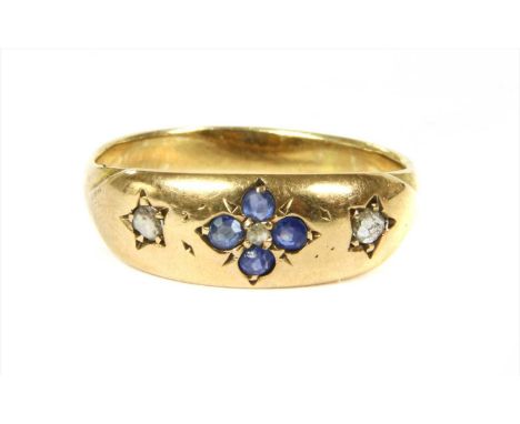 A 15ct gold sapphire and diamond ring, a rose cut diamond with a quatrefoil surround of round mixed cut sapphires, grain set,