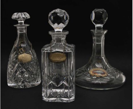 A group of three crystal glass decanters, to include a ship’s decanter, whisky decanter and tapering example, each with silve