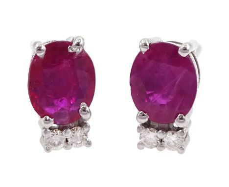 Pair of 18ct white gold oval ruby and diamond stud earrings, total ruby weight approx 1.10 caratCondition Report:Length =17mm