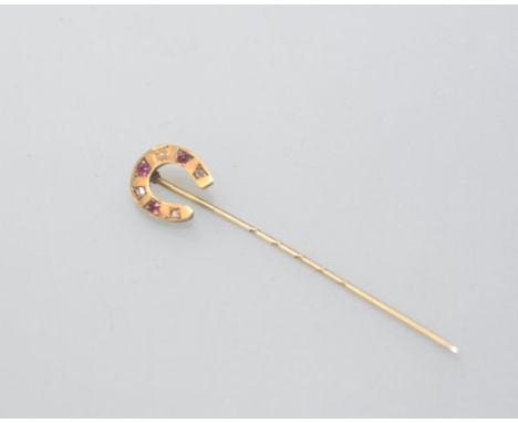 An Edwardian 9ct gold horseshoe stick pin, set with alternating rubies and diamonds, cased. 