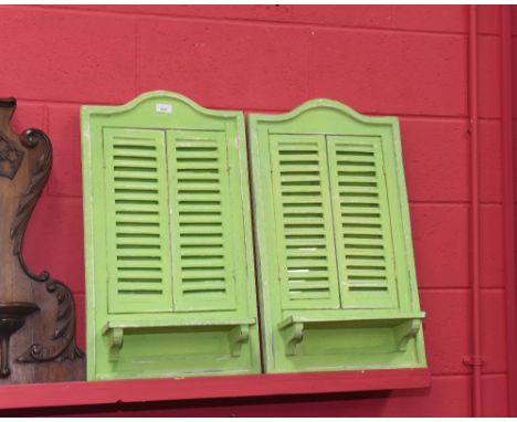 A pair of green painted shabby chic shuttered mirrors, each fitted with a shelf