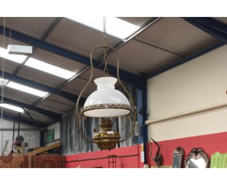 A hanging oil lamp with an opaque glass shade