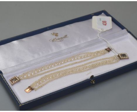 A pair of early 19th century seed pearl bracelets, each multi strand with cluster and bead rows on a seed pearl mounted glaze