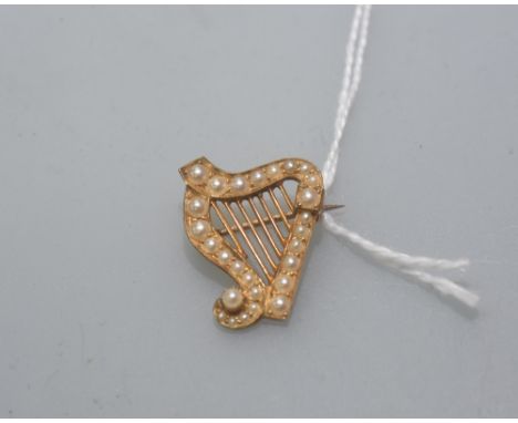 An Edwardian harp form brooch set with seed pearl and mounted in yellow metal (unmarked). 3.7 grams