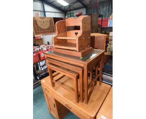 A nest of glass topped oak occasional tables, a chess board and chess pieces and an Arts & Crafts style book trough