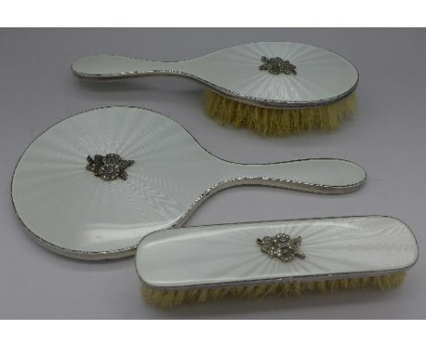 A three piece silver and enamel brush set by Adie Bros.