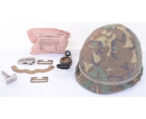 MIXED MILITARY ITEMS; US helmet with liner and camo cover, first aid dressing,3 buckles, brass plaque and WW1 brass military 