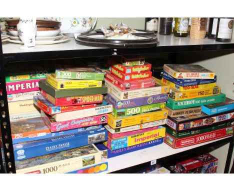 Large collection of vintage and modern jigsaw puzzles.