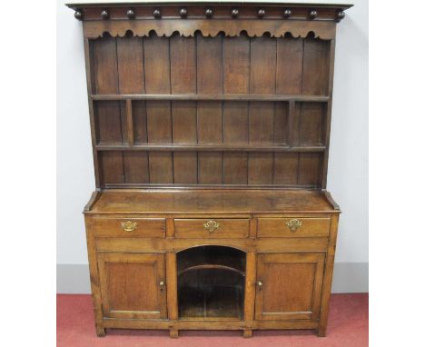 An XVIII Century and Later Oak Dresser, the rack with cornice applied with ball decoration, shaped frieze and two shelves, th
