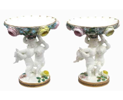 A Pair of Late XIX Century Moore Brothers Porcelain Comports, each with floral encrusted circular bowl raised on cherub suppo
