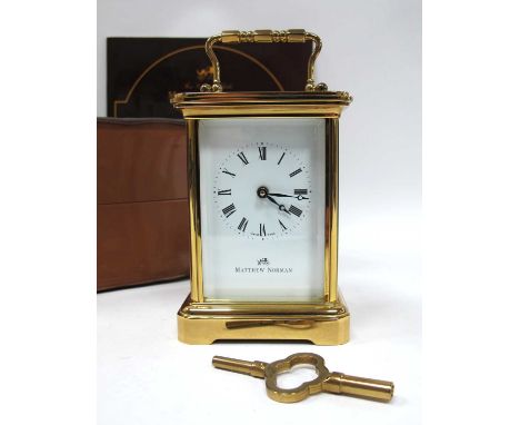 A Matthew Norman Brass Carriage Clock, within bevelled glass panels, the white enamel dial with Roman numerals, the back engr