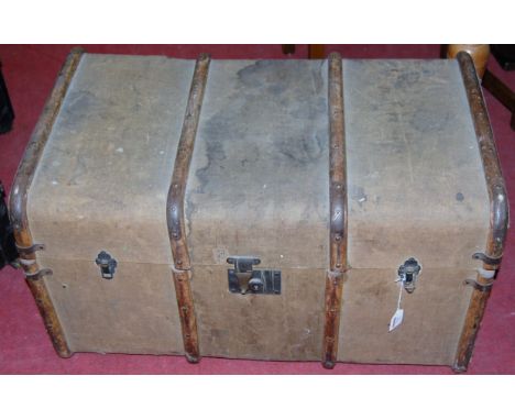 An early 20th century canvas clad wooden and metal bound hinge top travelling trunk