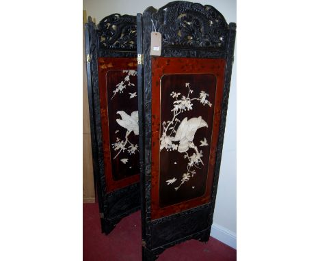 A Japanese Meiji period stained and carved four-fold dressing screen, fitted with lacquer panels with bone and mother of pear