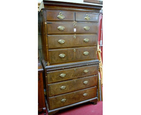 A George III walnut chest-on-chest, the upper section having feather and crossbanded graduated drawers within canted corners,