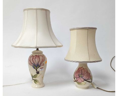 A Moorcroft pottery Magnolia pattern table lamp, h.53cm (including shade); together with another smaller example (2)