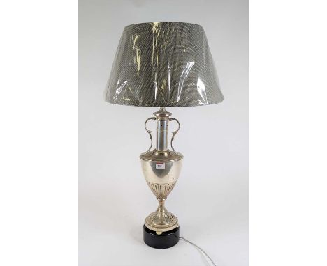 A silvered metal table lamp in the form of an urn standing on further ebonised base, height including shade 76cm