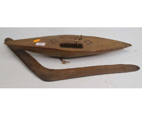 An Aboriginal carved hardwood boomerang, 54cm; together with a carved hardwood shield, h.47cm