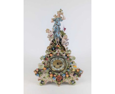 A continental pottery floral encrusted figural mantel clock, the enamel chapter ring with Arabic numerals and twin winding ho