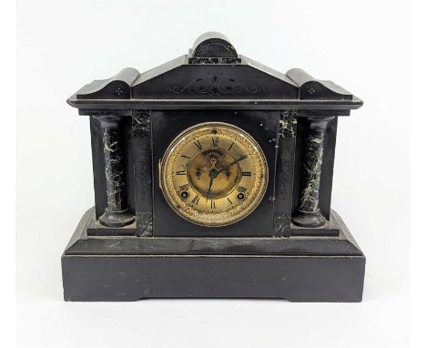 A Victorian black slate mantel clock of architectural form, the chapter ring showing Roman numeral markers and having twin wi