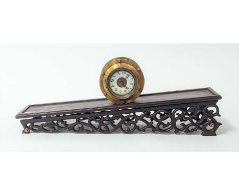 A reproduction brass gravity driven incline rolling clock, the enamel dial showing Arabic numerals, upon a carved hardwood in