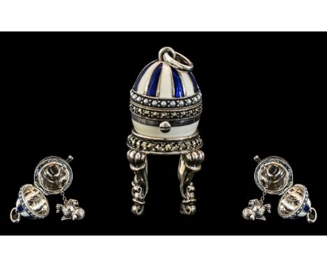 Faberge Style Silver and Enamel Egg on Stand, a silver egg with blue and white enamelling, and hinged opening to reveal a bir