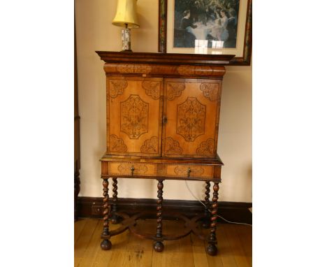 A William and Mary walnut olivewood and kingwood cabinet on stand, circa 1690, the moulded cornice above inlaid frieze drawer