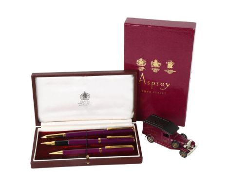 An Asprey, London trio pen set, fountain pen, rollerball and ballpoint pens, purple and gold metal trim, in leather presentat