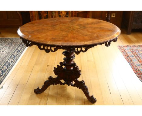 A Regency walnut circular centre table, with central stained floral marquetry inlaid panel, egg and dart moulding with foliat