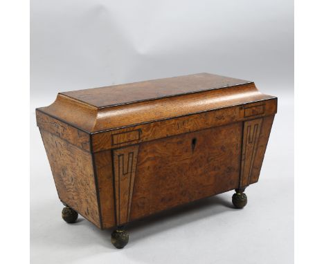 A Regency burr-walnut sarcophagus tea caddy, with ebonised moulding and brass bun feet, width 35cm, height 22cm, depth 18cmNo