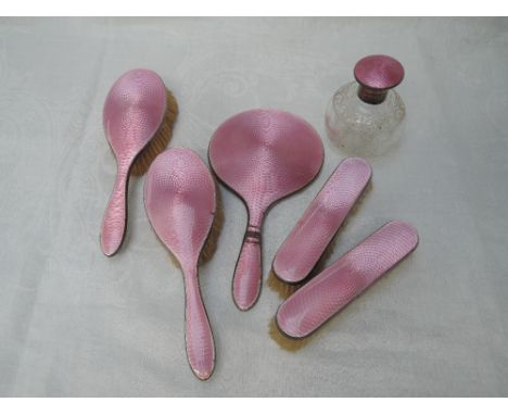 A five piece silver dressing table set and matching perfume bottle all having pink enamel guilloche decoration, Birmingham 19