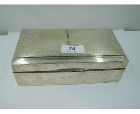 A silver cigarette box of rectangular form having engine turned wave decoration to lid with crest to cartouche and monogram t