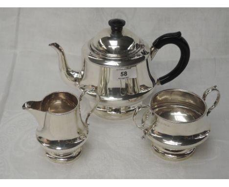 A silver three piece breakfast tea set of plain circular form having loop handles and indented decoration to rims, Birmingham