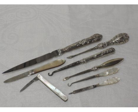 A small selection of HM silver and mother of pearl items including button hooks, manicure tools, paper knife and two folding 