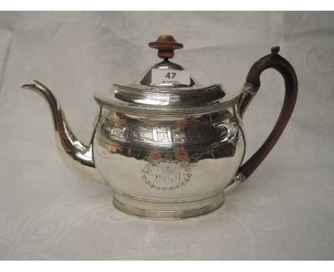 A Georgian silver teapot of oval form having bright cut swag and garland decoration, monogrammed cartouche. fruitwood handle 