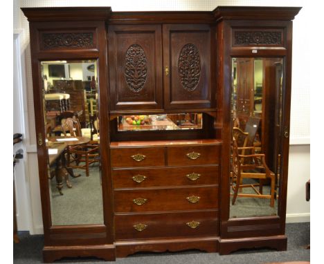 A Victorian mahogany inverted break front wardrobe, ogee cornice, two central covered doors with carved oval panelled motifs 