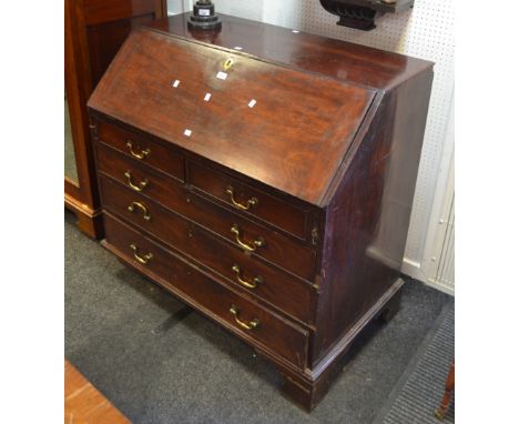 A George III mahogany bureau, full front enclosing writing surface, central covered door flanked by spiraling columns and pig