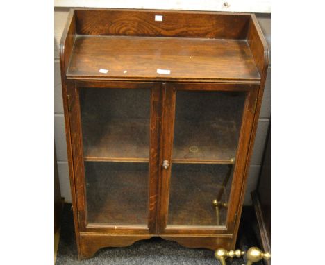 An early 20th century oak and elm glazed bookshelf, enclosing two shelves, shaped bracket feet etc.  (2)
