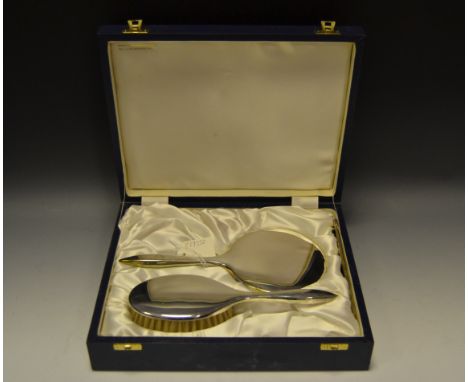 An Elizabeth II silver dressing table suite, comprising hand mirror, hair brush and comb, quite plain, Birmingham 2003, cased