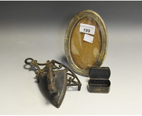 A silver oval photograph frame; a Victorian snuff box; an early 20th Century flat iron