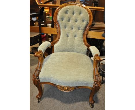 A Victorian carved mahogany framed open armchair 
with button upholstery.